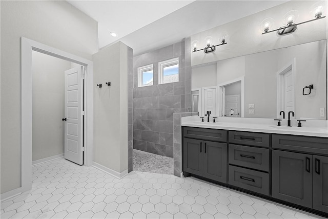 bathroom featuring double vanity, a walk in shower, a sink, and tile patterned floors