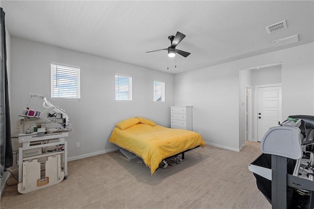 bedroom featuring baseboards, multiple windows, visible vents, and light colored carpet