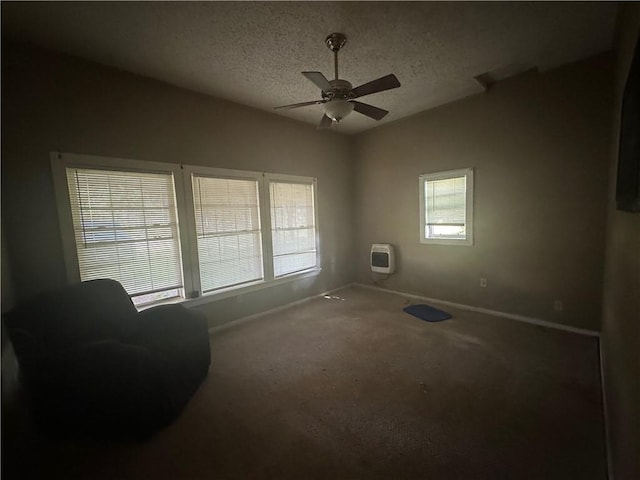 sitting room featuring heating unit, ceiling fan, carpet, and a textured ceiling