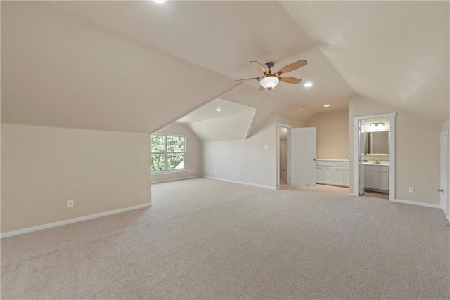 additional living space with ceiling fan, light carpet, and vaulted ceiling