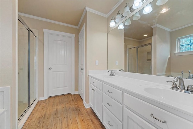 bathroom featuring hardwood / wood-style flooring, vanity, an enclosed shower, and ornamental molding