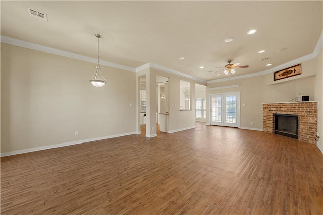 unfurnished living room featuring ceiling fan, dark hardwood / wood-style flooring, ornamental molding, and a brick fireplace