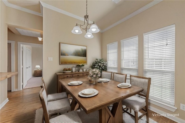 dining area with a chandelier, hardwood / wood-style flooring, and crown molding