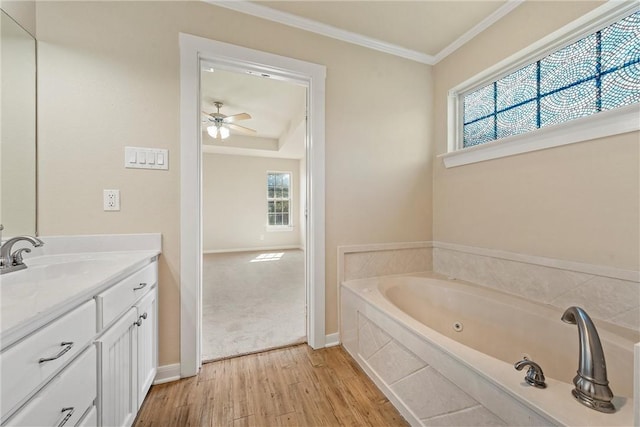 bathroom featuring vanity, crown molding, ceiling fan, wood-type flooring, and tiled bath