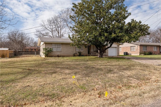 view of front of property with a garage, a front lawn, and central AC unit