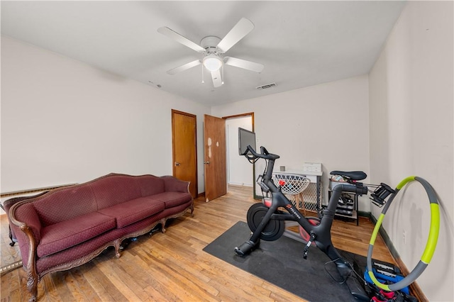 exercise area with light hardwood / wood-style floors and ceiling fan