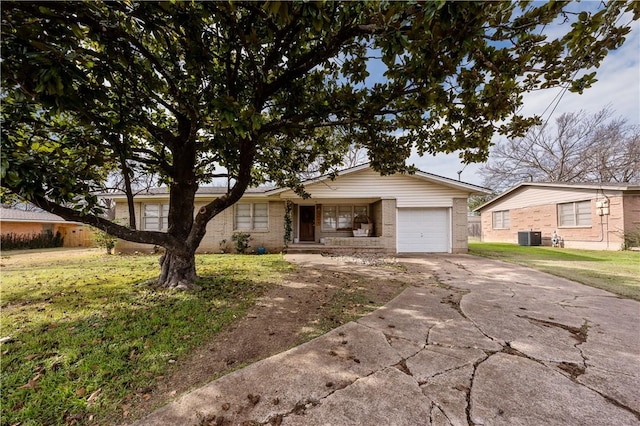 ranch-style house featuring a garage, a front yard, and cooling unit