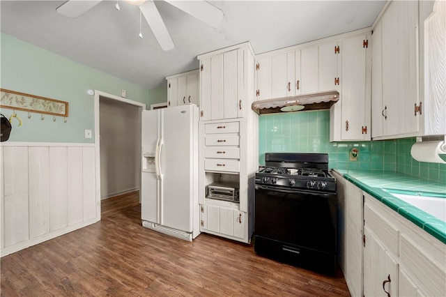 kitchen with white fridge with ice dispenser, tile counters, white cabinetry, dark hardwood / wood-style floors, and black range with gas cooktop