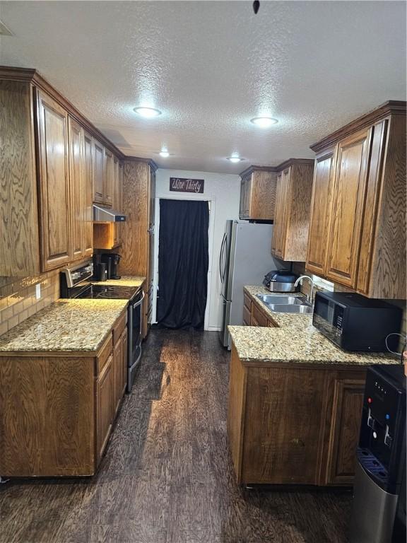 kitchen with light stone countertops, a textured ceiling, dark wood-type flooring, sink, and black electric range oven