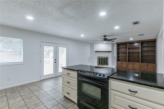 kitchen featuring electric range, french doors, a textured ceiling, and a brick fireplace