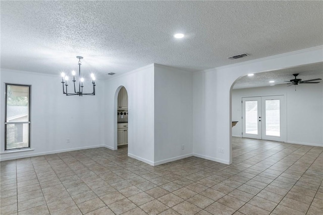 tiled spare room featuring french doors, ceiling fan with notable chandelier, a textured ceiling, and ornamental molding