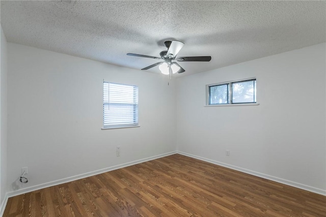 spare room featuring a textured ceiling and dark wood-type flooring