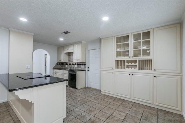 kitchen featuring white cabinetry, kitchen peninsula, decorative backsplash, light tile patterned flooring, and black appliances