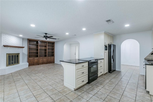 kitchen with ceiling fan, a textured ceiling, a fireplace, white cabinets, and black appliances