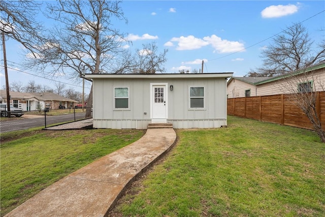 view of front of house featuring board and batten siding, fence private yard, and a front yard