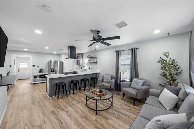 living area with recessed lighting, visible vents, and light wood-style floors