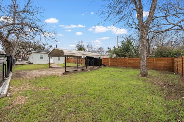 view of yard with a detached carport, a fenced backyard, and dirt driveway