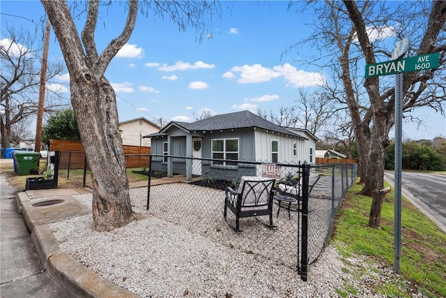 bungalow-style home featuring board and batten siding, roof with shingles, and fence