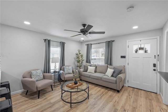 living room featuring baseboards, a ceiling fan, light wood-style flooring, and recessed lighting