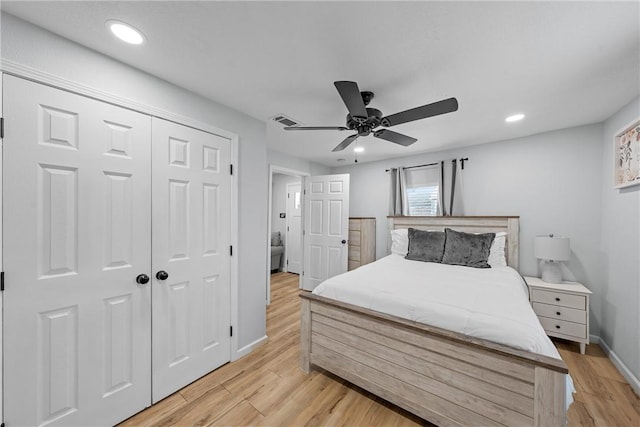 bedroom featuring light wood finished floors, a closet, and recessed lighting