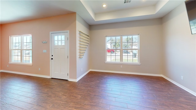 foyer entrance with recessed lighting, a raised ceiling, visible vents, dark wood-type flooring, and baseboards