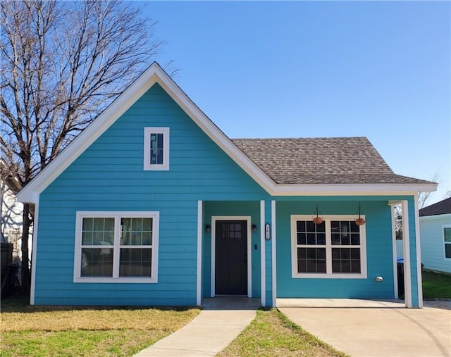 bungalow with a front lawn, a porch, and roof with shingles