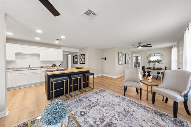 unfurnished living room featuring ceiling fan and light hardwood / wood-style floors