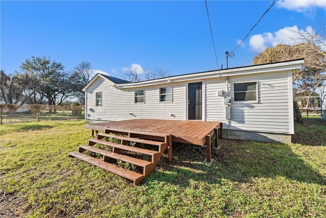 rear view of house with a lawn and a wooden deck