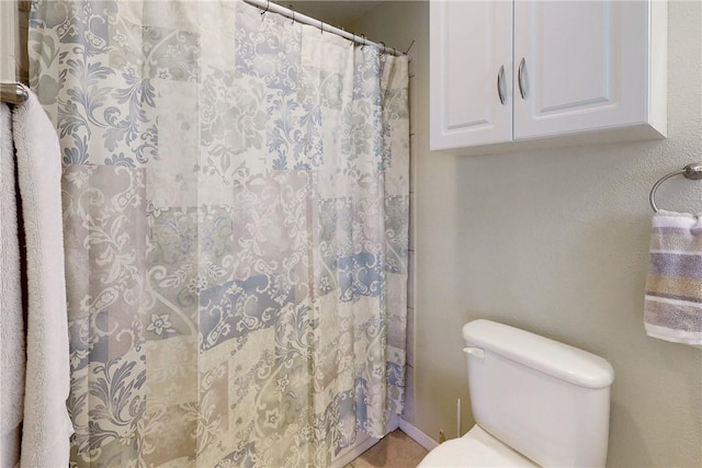 bathroom with a shower with shower curtain and toilet