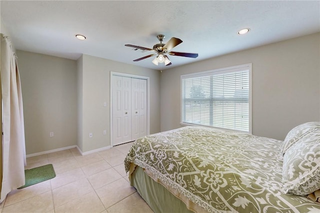 tiled bedroom with ceiling fan and a closet