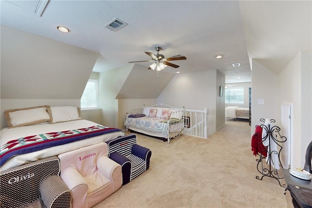 bedroom with ceiling fan, vaulted ceiling, light carpet, and multiple windows