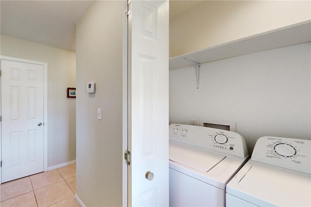 clothes washing area featuring washer and dryer and light tile patterned floors