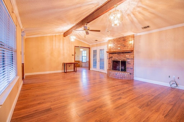 unfurnished living room with vaulted ceiling with beams, hardwood / wood-style flooring, a fireplace, ceiling fan with notable chandelier, and ornamental molding