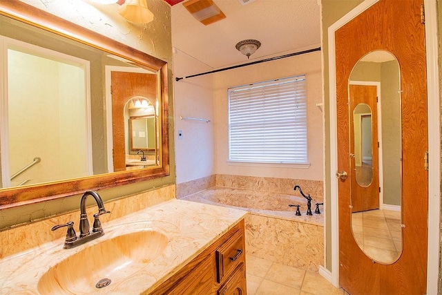 bathroom featuring tile patterned floors, vanity, and tiled bath