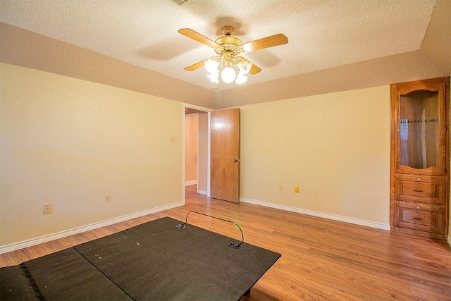 empty room featuring a textured ceiling, hardwood / wood-style flooring, and ceiling fan