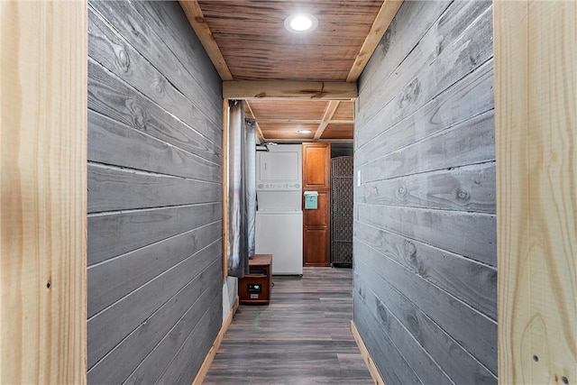 corridor featuring stacked washer and dryer, wooden walls, wooden ceiling, and dark hardwood / wood-style floors