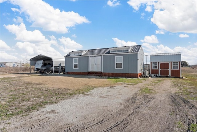 view of front of home featuring a carport and a shed