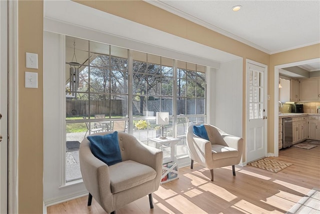 living area with light hardwood / wood-style flooring and ornamental molding