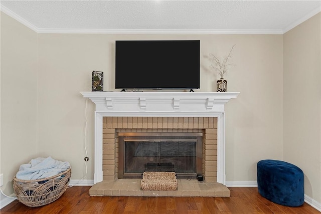 room details with a textured ceiling, wood-type flooring, a fireplace, and ornamental molding