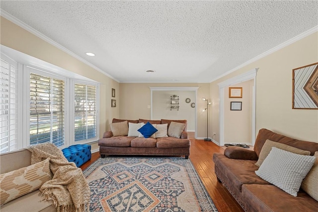 living room featuring hardwood / wood-style floors, a textured ceiling, and ornamental molding