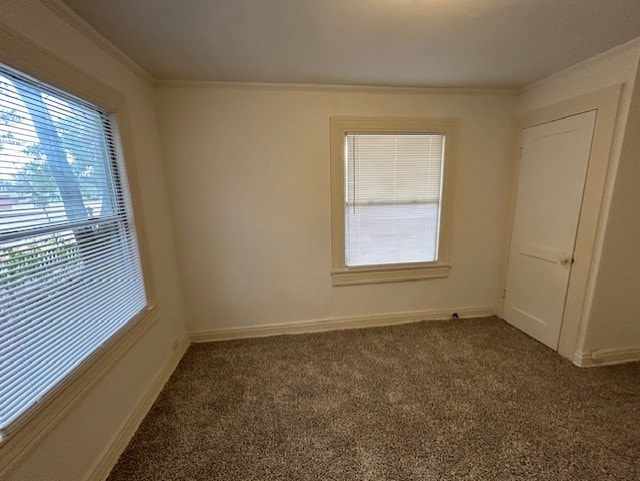 empty room with dark colored carpet and crown molding