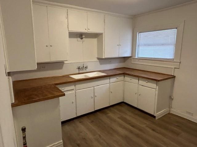 kitchen with dark hardwood / wood-style floors, white cabinetry, and sink