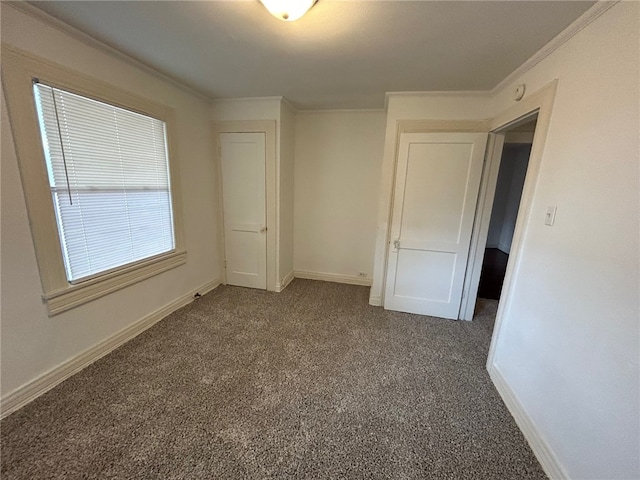 unfurnished bedroom with dark colored carpet and ornamental molding