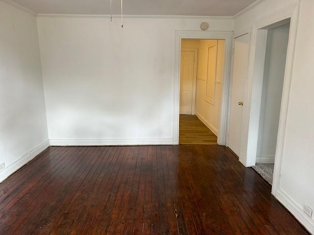 unfurnished room featuring dark hardwood / wood-style flooring and crown molding