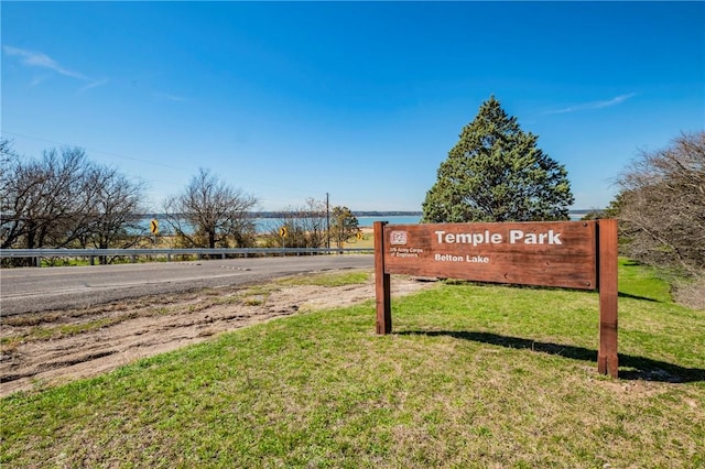 community sign with a yard and a water view