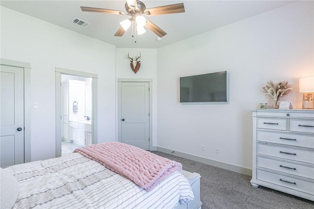 carpeted bedroom with ensuite bath and ceiling fan