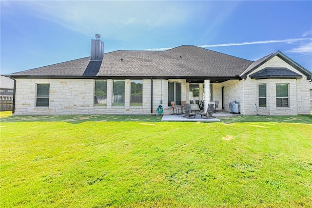 back of house with a patio and a lawn