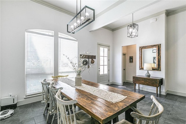 dining room featuring crown molding, a healthy amount of sunlight, and a notable chandelier