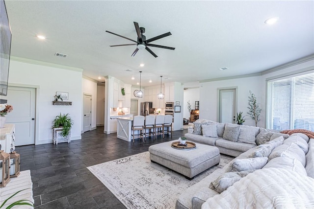 living room featuring ceiling fan and ornamental molding