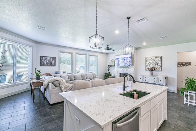 kitchen featuring dishwasher, white cabinetry, sink, and an island with sink